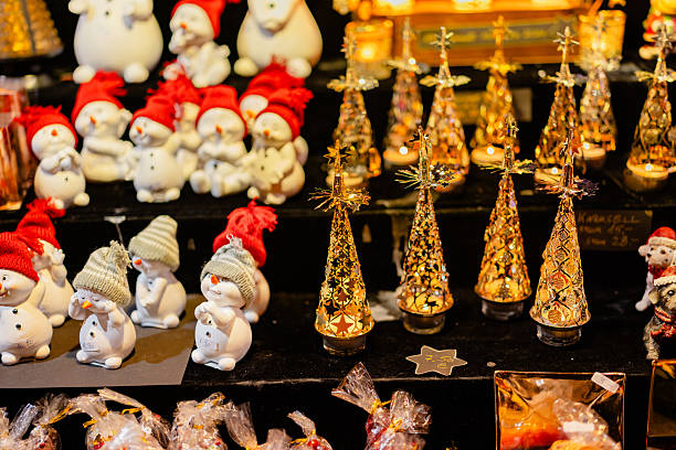 Snowman figurines and illuminated Christmas ornaments at holiday market.