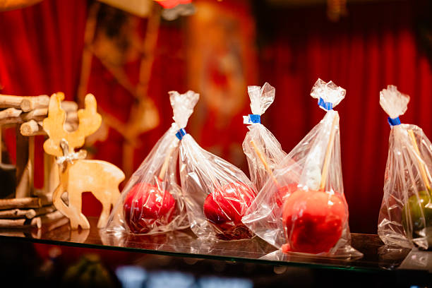 Red candy apples wrapped in plastic at Christmas market.