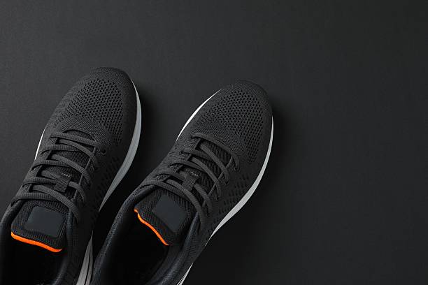 istock Pair of stylish sneakers on a black background 2251728088