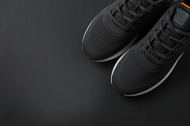 istock Pair of stylish sneakers on a black background 2251728090