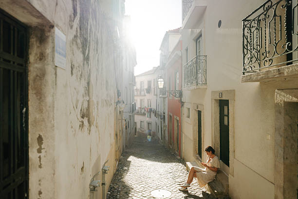 Photo of a woman using mobile phone, while on a city break vacation in Lisbon, Portugal