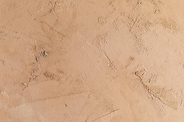 istock Clay or dark beige, uneven, rough wall texture background 2251731892