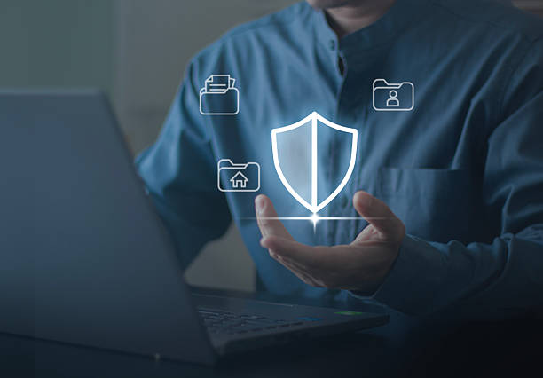 istock Business professional presenting digital security shield over a laptop with cloud icons, symbolizing cybersecurity, data protection, privacy, secure access, and risk management for digital workplaces. 2251737655
