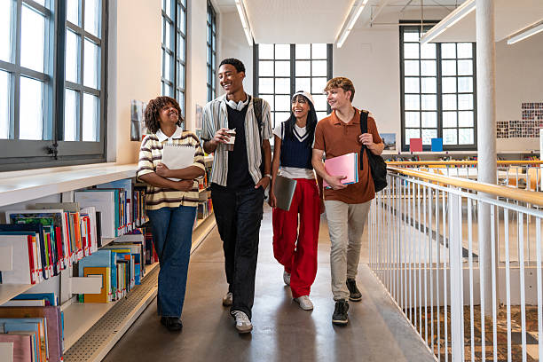 istock Diverse students walking and smiling in university library 2251743540