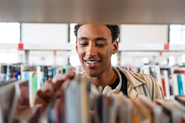 istock Young student choosing book for research in university library 2251743716