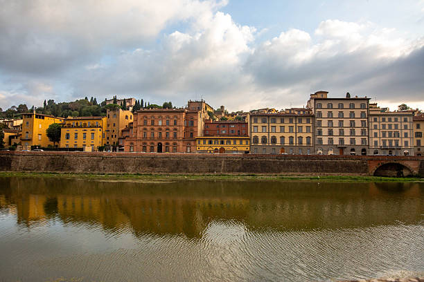 View of the Santa Trinita Bridge and the reflection of the buildings on the Arno River at the time of the sunset. Florence, Italy. October 1, 2018