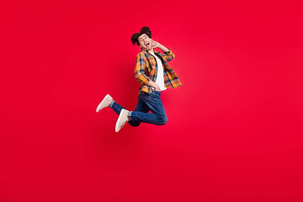 istock Photo of sweet attractive guy dressed checkered clothes jumping high looking back empty space isolated red color background 2251747879