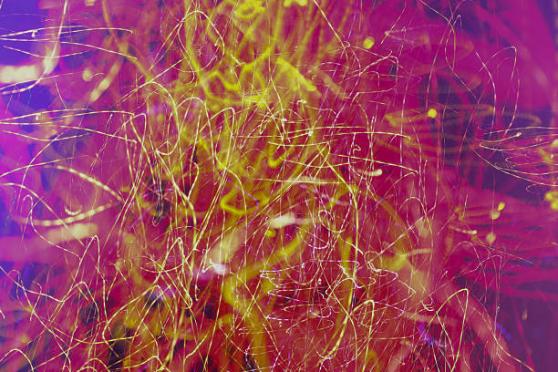 Vertical abstract light painting creates a rich and dynamic background featuring fiery red and golden-yellow light trails. Long exposure captures a multitude of intertwined lines and spots, mimicking an energy burst or chaotic nightlife.