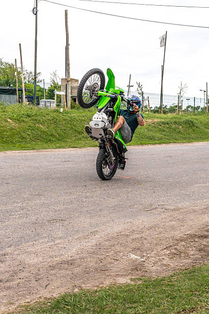 San Isidro, Buenos Aires Province, Argentina - 7 December 2025: Man performing a vertical motorcycle stunt known as a wheelie during his training session