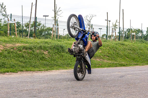 Mature man practicing martial arts outdoors, kicking a punching bag made of tires