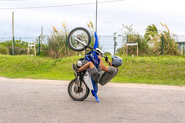 Sports photo of biker who is a professional rider in enduro and motocross outside. Off-road bike and man in the nature making stunt. Forest and sand, the person using sport eqipment.