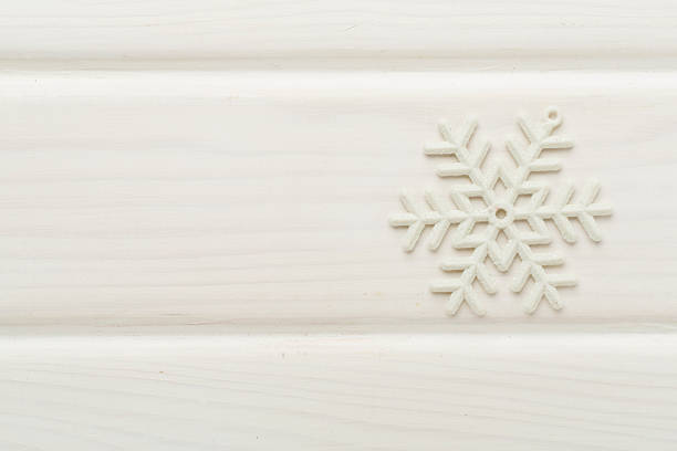 Beautiful snowflake on woden background, top view
