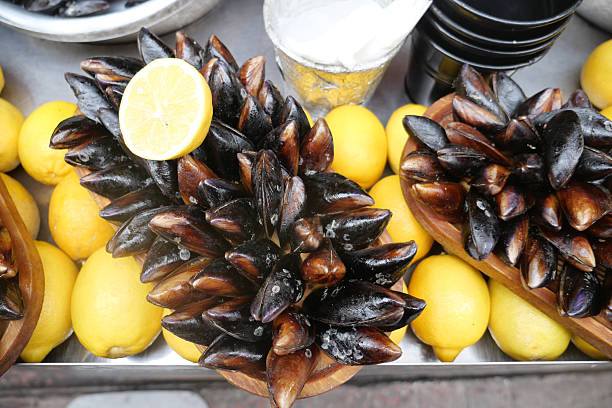 Mussels displayed beautifully with lemons at a market stand.