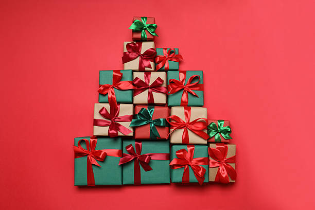 istock Gift boxes in the form of a Christmas tree on a red background, top view 2251773025
