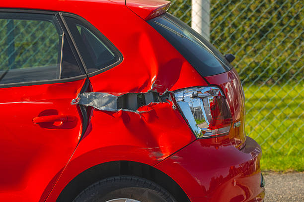 istock Red compact car with significant rear side collision damage parked outdoors. 2251774905