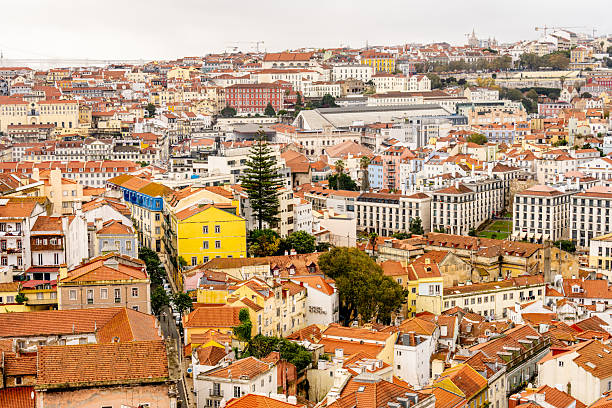 Lisbon Portugal December 05 2025. A wide hillside view shows dense residential buildings across central Lisbon under cloudy daylight conditions.