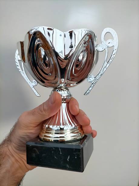 istock a man holding a trophy in his hand 2251784935