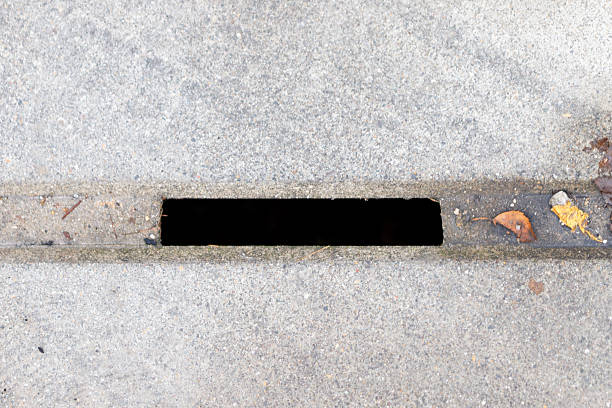 Street gutter drain slot cut into concrete for urban water runoff