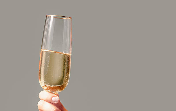 istock Hand holding champagne flute with copy space celebrating 2251795049