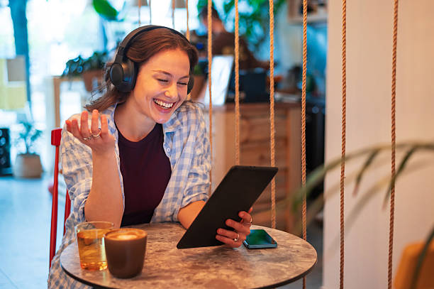 istock Young smiling woman in the coffee shop using digital tablet 2251798813