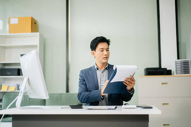istock Asian businessman working with working notepad, tablet and laptop documents talking on the smartphone, tablet and laptop 2251801192
