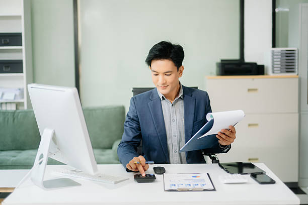 istock Asian businessman working with working notepad, tablet and laptop documents talking on the smartphone, tablet and laptop 2251801194