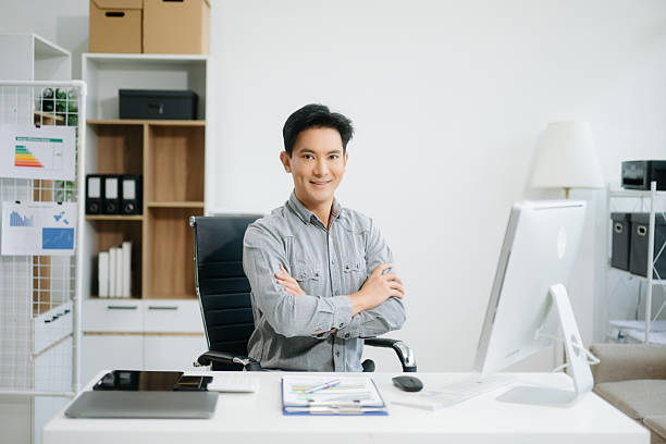istock Young attractive Asian man smiling thinking planning writing in notebook, tablet and laptop 2251801219