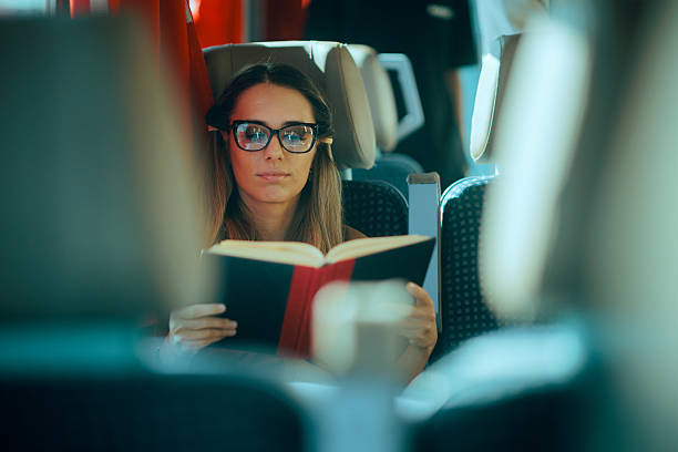 istock Train Traveler Reads a Book While Waiting to Arrive to Destination 2251803901