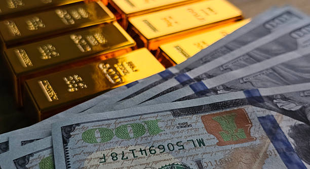 istock Gold bars and cash currency displayed together on a flat surface 2251805342