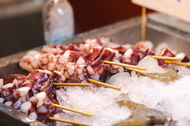Asian street food market.Seafood (octopus) skewers sales on street food market stand.Phuket Island - Thailand.