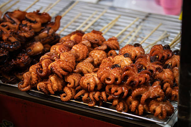 Asian street food market.Seafood (octopus) skewers sales on street food market stand.Phuket Island - Thailand.