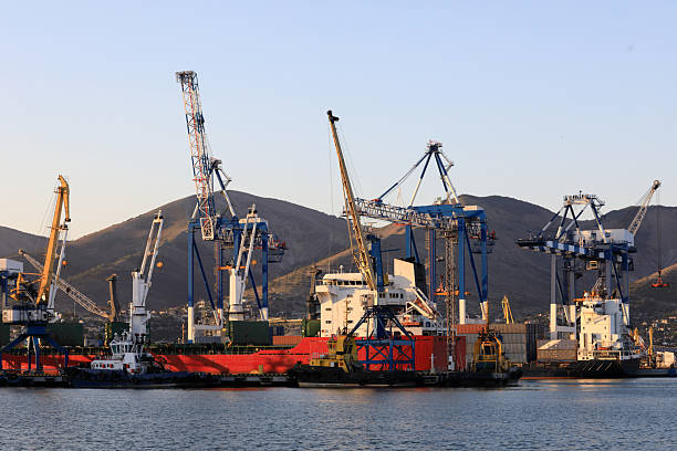 istock Cargo vessel docked at industrial port with large cranes 2251815114