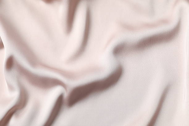 istock Beige silk satin. Shiny smooth fabric. Soft folds. Luxury background with space for design. Flat table, top view 2251819481