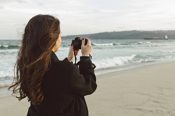 istock Smiling female photographer holding a camera on a 2251819509