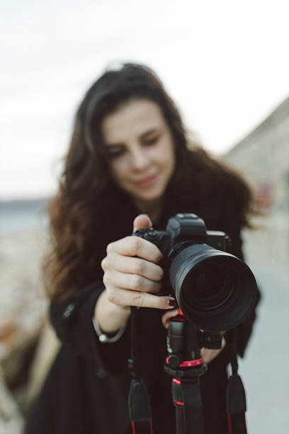 istock Female photographer adjusting professional camera 2251820065
