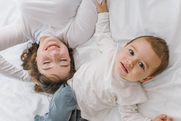 istock Happy mother and baby lying together on a soft 2251820182