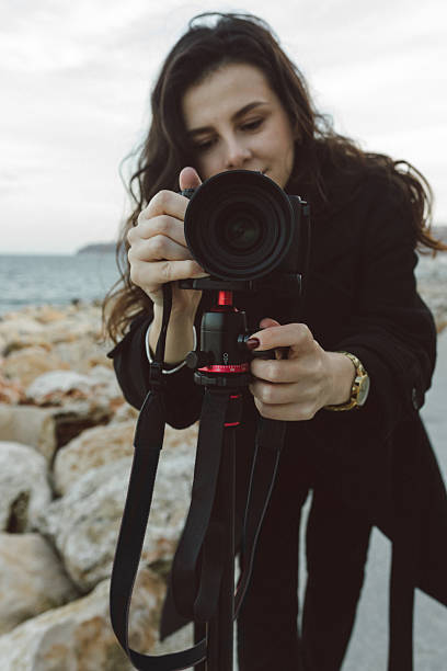 istock Female photographer adjusting professional camera 2251820290