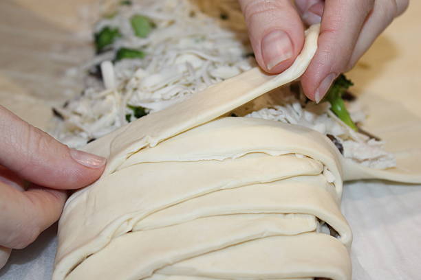 istock Hands wrap dough around vegetables and cheese in a kitchen during meal preparation in the evening 2251820681