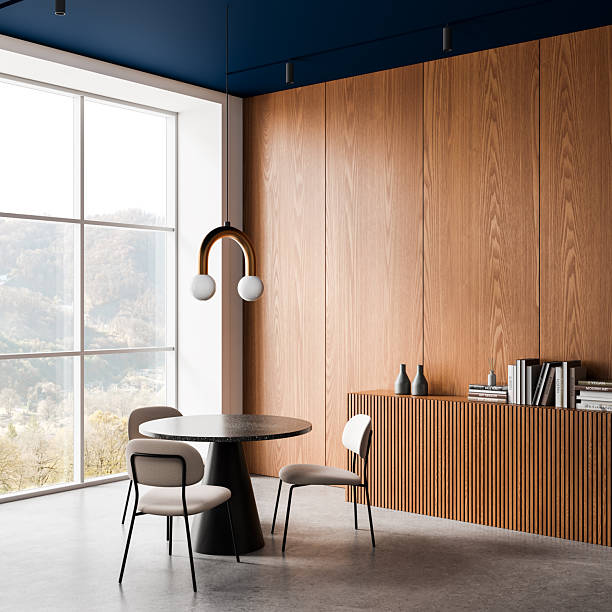 istock Modern interior dining space with wood panel wall, minimalist round table, and soft neutral chairs in natural daylight setting. 3D Rendering 2251821493