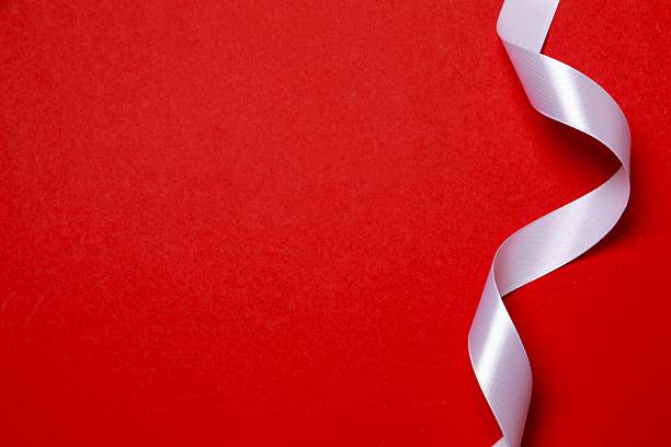 istock Beautiful white silk ribbon on red background, space for text 2251821585