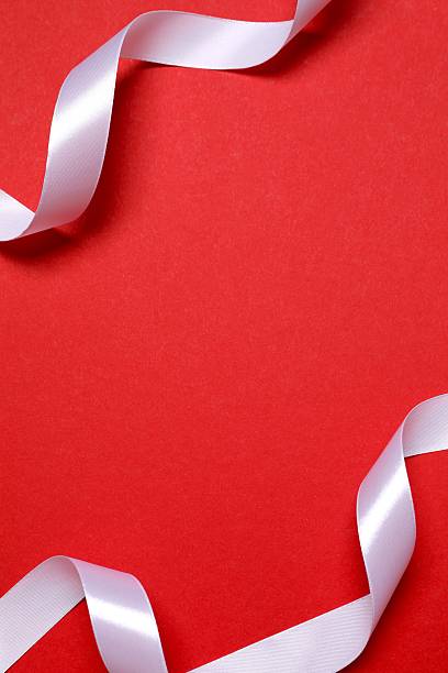 istock Beautiful white silk ribbon on red background, space for text 2251821594