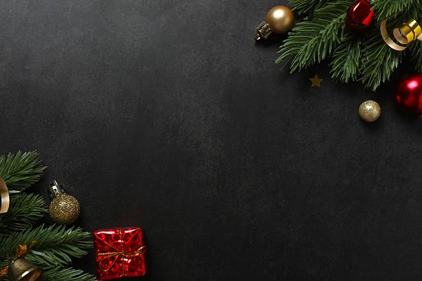 istock Christmas pine branches with ornaments on black background. A luxurious Xmas background with copy space for seasonal greetings or design 2251823645