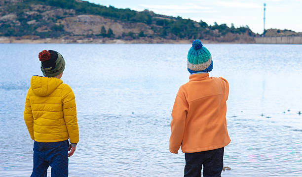 Children looking at fish in a pond.