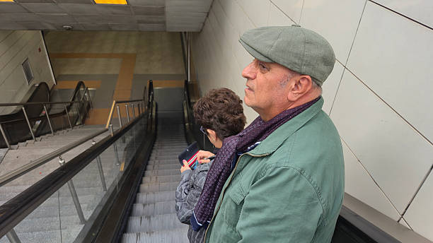 Mature couple riding on escalator. They're going to the subway.