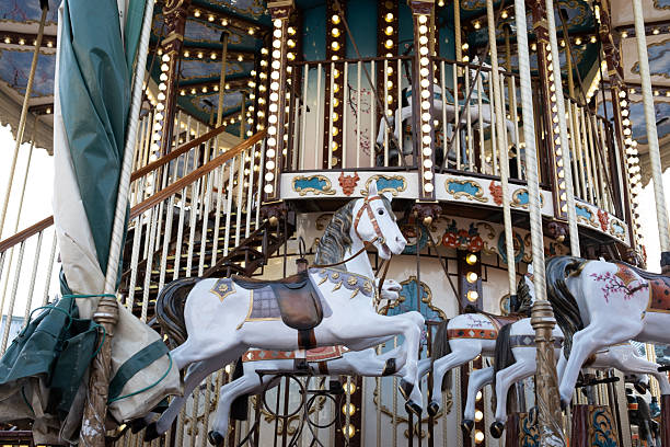 A beautiful vintage double-decker merry-go-round. White horses with ornate saddles spin under golden lights, creating a magical, nostalgic and festive atmosphere.