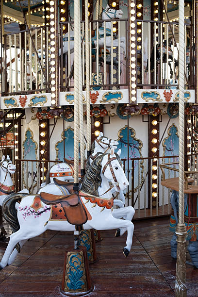 A beautiful vintage double-decker carousel with illuminated white horses. A classic fairground attraction evoking nostalgia, magic, and childhood joy.