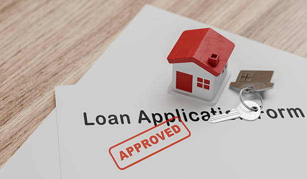 istock Small house model on paperwork with “APPROVED” stamp — property purchase, mortgage approval, lending 2251833395