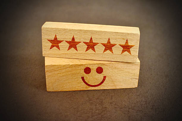 Emotion face and Star symbol blocks on table background. Service rating, ranking, customer review, satisfaction, evaluation and feedback concept