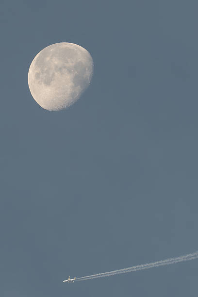 istock Full Moon and Airplane with Contrail in Clear Sky 2251836904