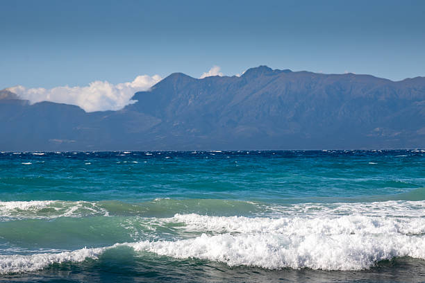 beautiful waves on a sunny day on an emerald beach and mountain coast. Mediterranean Sea.